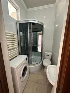 a bathroom with a washing machine and a toilet at B&B apartments in Shymkent