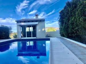 a swimming pool with a house in the background at Casa tranquila in Teulada