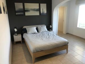 a bedroom with a bed with white sheets and pillows at Casa tranquila in Teulada +29 photos