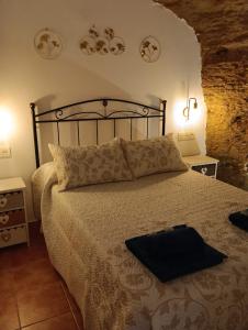 Un dormitorio con una cama con una bolsa negra. en Casa Cueva Sol y Luna Setenil en Setenil