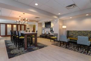 布赖顿Hampton Inn Brighton Mi的一间带桌椅的餐厅和客厅