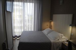 a bedroom with a bed and a large window at Yes Hotel Touring & SPA in Rimini