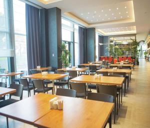 a restaurant with wooden tables and chairs and windows at Hampton By Hilton Bolu in Bolu