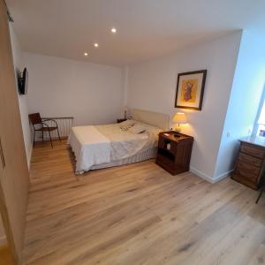 - une chambre avec un lit et une table avec une lampe dans l'établissement Ancora Apartment, à Vilanova i la Geltrú