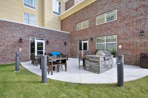 a patio with a grill and a brick building at Homewood Suites By Hilton Augusta Gordon Highway in Augusta