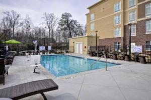 una piscina en un hotel con sillas y un edificio en Homewood Suites By Hilton Augusta Gordon Highway en Augusta