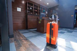 una valigia arancione seduta sul pavimento in una stanza di Four Points Marriott Salt Lake City Airport a Salt Lake City