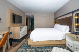 a hotel room with a bed and a flat screen tv at Four Points by Sheraton Salt Lake City Airport in Salt Lake City