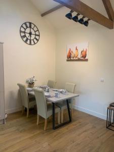 a dining room with a table and chairs and a clock at Barford barn holiday cottage in Darlington