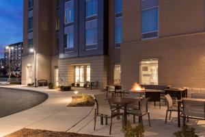 un patio avec des tables et des chaises en face d'un bâtiment dans l'établissement Hampton Inn & Suites Indianapolis-Keystone, IN, à Indianapolis