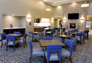 um restaurante com mesas e cadeiras e uma lareira em Homewood Suites By Hilton West Fargo/Sanford Medical Center em Fargo