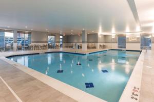 a large swimming pool with blue water in a building at Hampton Inn & Suites Indianapolis-Keystone, IN in Indianapolis