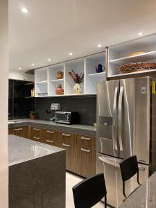 una cocina con nevera de acero inoxidable y armarios en Corazón de condesa en Ciudad de México