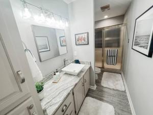 a white bathroom with a sink and a toilet at Long Island Condo in Hot Springs