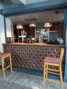 ein Restaurant mit einer Bar mit einer Bank in der Unterkunft OYO Ivy Hotel in Skegness