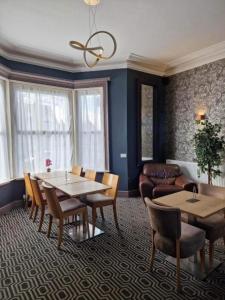 OYO Ivy Hotel في سكيجنيس: غرفة معيشة مع طاولة وكراسي وأريكة