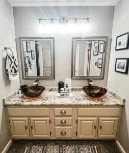 a bathroom with two sinks and two mirrors at Long Island Condo in Hot Springs