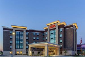 a hotel building with an american flag in front of it at Hampton Inn & Suites Burlington in Burlington