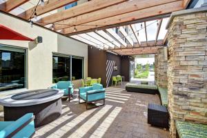 a patio with blue chairs and a stone wall at Home2 Suites by Hilton Springfield North in Springfield
