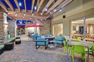 a patio with tables and chairs in a restaurant at Home2 Suites by Hilton Springfield North in Springfield