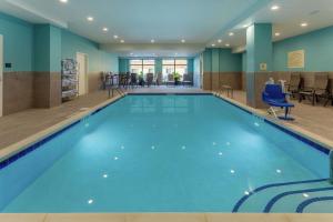 Hampton Inn & Suites Burlington في برلينغتون: مسبح كبير بمياه زرقاء في غرفة الفندق