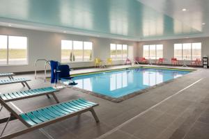 una gran piscina con sillas y mesas en Tru By Hilton Cedar Rapids Westdale en Cedar Rapids