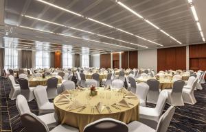 a large room with tables and chairs in a room at DoubleTree by Hilton Dubai Al Jadaf in Dubai
