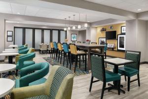 Hampton Inn Champaign Southwest في شامبين: غرفة طعام مع طاولة وكراسي طويلة