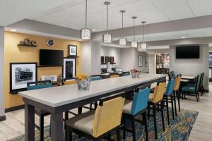 尚佩恩Hampton Inn Champaign Southwest的一间配有大桌子和椅子的大餐厅