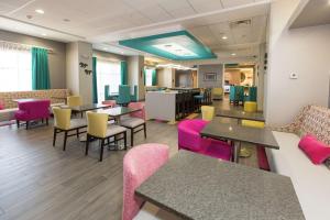 una sala d'attesa con tavoli e sedie rosa di Hampton Inn Mustang a Mustang