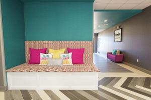 a bench in a room with colorful pillows on it at Hampton Inn Mustang in Mustang