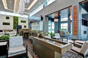 a lobby of a hotel with chairs and tables at Embassy Suites By Hilton Plainfield Indianapolis Airport in Plainfield