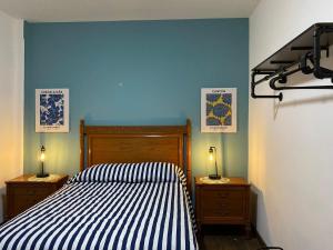 um quarto com uma cama listrada e duas mesas de cabeceira em Corazón de condesa em Cidade do México