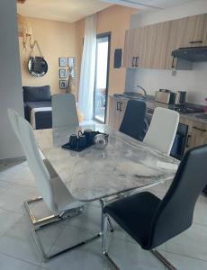 stół jadalny z krzesłami i kuchnia w obiekcie Cozy appartement w mieście LAl-Ara’isz