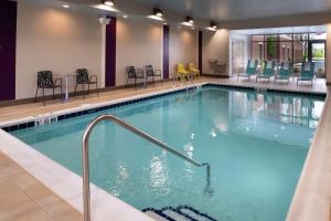 einen großen Pool mit Stühlen und Tischen in der Unterkunft Home2 Suites By Hilton New Albany Columbus in New Albany