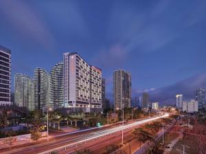 un perfil urbano con edificios altos y luces de la calle en Hilton Garden Inn Sanya en Sanya