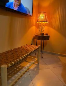 Pokój z ławką, lampą i telewizorem w obiekcie Cozy appartement w mieście LAl-Ara’isz