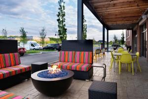 een patio met 2 stoelen en een vuurplaats bij Home2 Suites By Hilton New Albany Columbus in New Albany