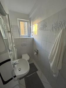 a bathroom with a sink and a toilet and a window at SkyLineApartment in Frankfurt/Main