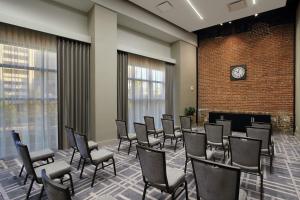 a waiting room with chairs and a clock on a brick wall at Canopy By Hilton Columbus Downtown Short North in Columbus