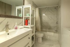 a bathroom with a sink and a toilet and a shower at Cozy Condo 2BDR MTL Downtown- 4410 in Montreal