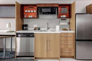 a kitchen with a sink and a refrigerator at Home2 Suites By Hilton Salisbury in Salisbury