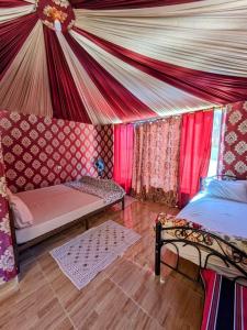 Habitación con tienda de campaña, cama y sofá en Shahrazad desert, Wadi Rum, en Wadi Rum