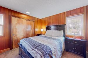 Un dormitorio con una cama con paredes de madera y una ventana en The Lucky Starfish en Lincoln City