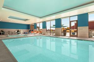 una gran piscina en un hotel con ventanas en Hampton Inn West Valley Salt Lake City, en West Valley City