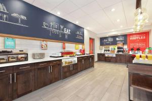 a large kitchen with wooden cabinets in a restaurant at Hampton Inn West Valley Salt Lake City in West Valley City