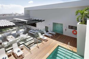Zimmer mit Pool und Stühlen sowie einem Gebäude in der Unterkunft Homewood Suites By Hilton Santo Domingo in Santo Domingo
