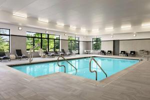 a pool in a hotel room with chairs and tables at Homewood Suites By Hilton Horsham Willow Grove in Horsham