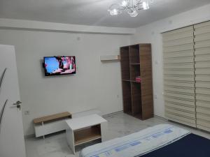 Habitación con cama y TV en la pared. en Jordanovi Premium Apartment en Kavadarci