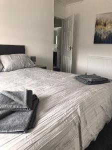 a bedroom with a large bed with towels on it at 3 Bedroom House Brighouse in Brighouse